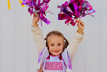 little girl cheering with pom poms