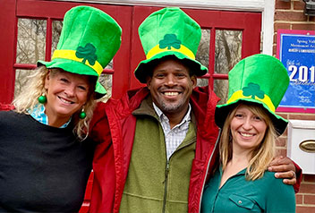 Three teachers wearing St. Patrick's Day hats