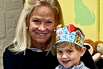 Staff holding student wearing birthday crown